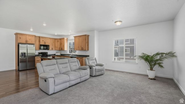 Carpeted living area with recessed lighting and wood finished floors | Image 11