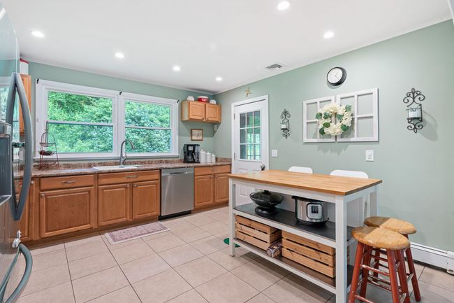 Kitchen featuring appliances with stainless steel finishes, a sink, recessed lighting, light tile patterned floors, and stone counters | Image 22