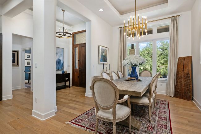 Formal dining space featuring a chandelier, a high ceiling, light wood-style floors, and recessed lighting | Image 5