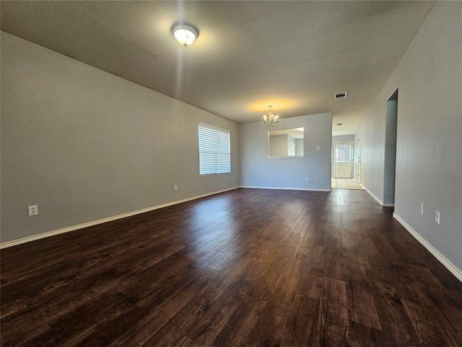 Spare room with a chandelier and dark wood finished floors | Image 8