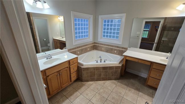 First Floor Full bath with a tub with jets, tile patterned floors, toilet, and a sink | Image 27