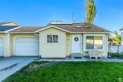 Ranch-style home featuring a garage and a front yard | Image 1