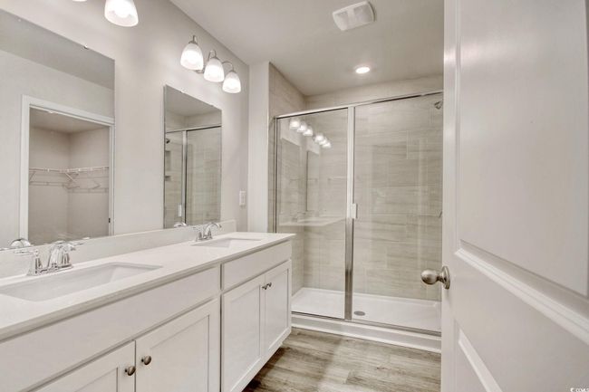 Bathroom featuring vanity, wood-type flooring, and a shower with door | Image 22