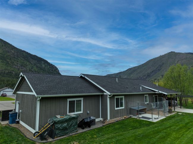 Rear view of house with a mountain view, a patio, and roof with shingles | Image 47