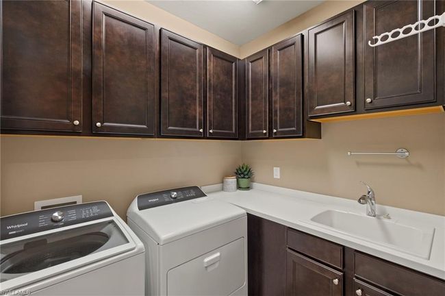 Clothes washing area with cabinets, independent washer and dryer, and sink | Image 27