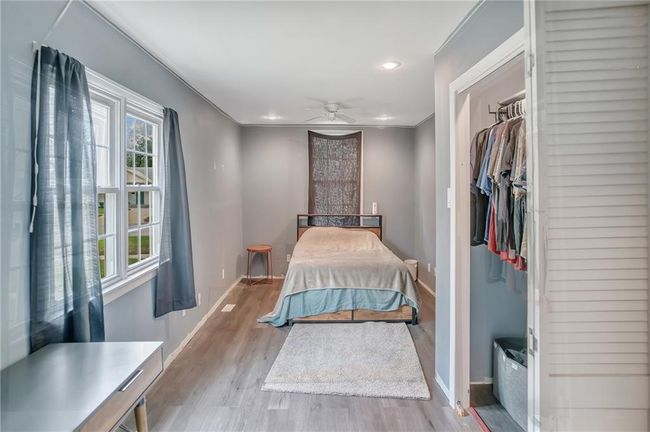 Bedroom with baseboards, wood finished floors, recessed lighting, and a closet | Image 11