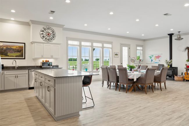 Kitchen with appliances with stainless steel finishes, a center island, a wood stove, and visible vents | Image 8