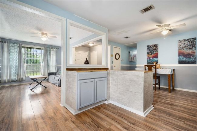 Kitchen featuring visible vents, wood finished floors, baseboards, ceiling fan, and gray cabinets | Image 10