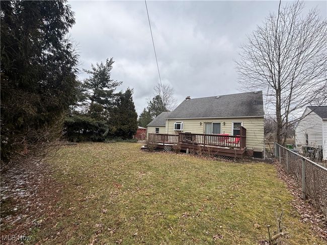 Rear view of house featuring fence, a lawn, and a wooden deck | Image 29