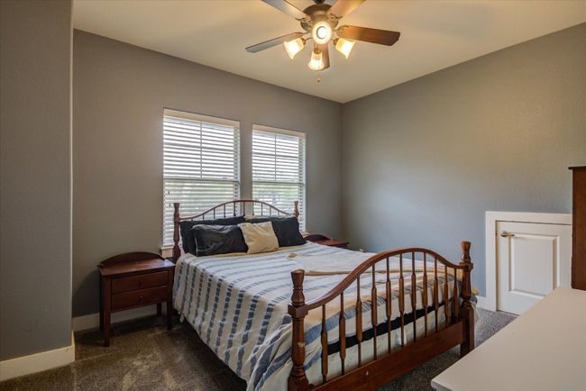Bedroom with walk-in closet, carpet floors, and ceiling fan | Image 28