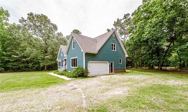 View of home's exterior featuring driveway, roof with shingles, a garage, and a lawn | Image 4