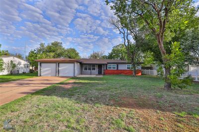 Ranch-style house featuring a front lawn and a garage | Image 2