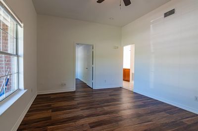 Spare room with dark wood-type flooring and ceiling fan | Image 3