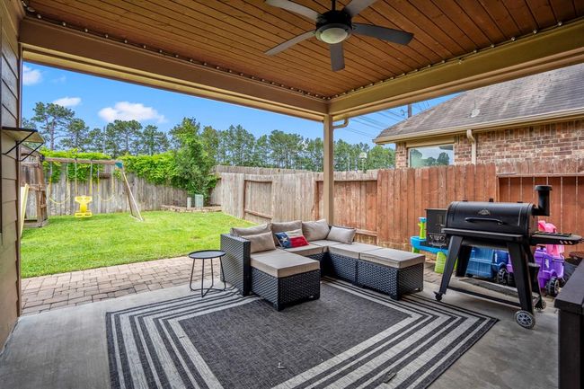Step outside to the inviting covered patio, where a striking wood-plank ceiling adds warmth and character. The paver stone patio extends the space beautifully, flowing into a lush, green lawn — perfect for relaxing or entertaining outdoors. | Image 31