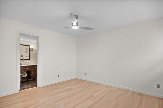 Unfurnished bedroom featuring wood finished floors, baseboards, and a sink | Image 12