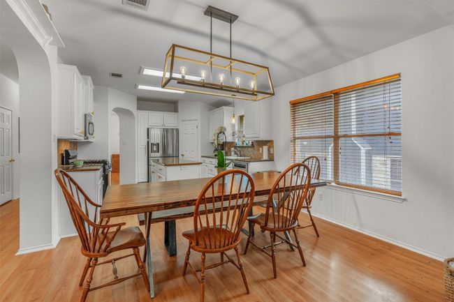 Dining space with arched walkways and light wood-style floors | Image 14