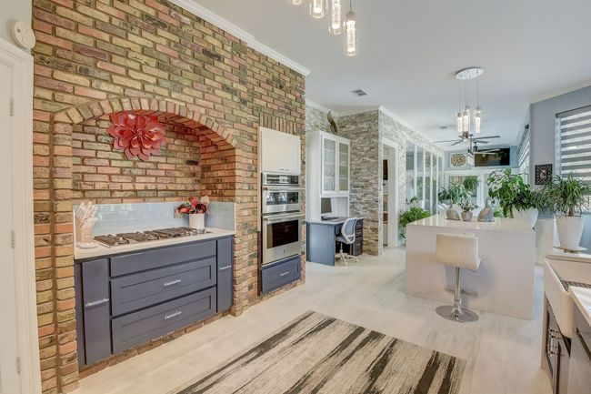 Culinary delight with stainless steel appliances, custom cabinetry, and glass backsplash | Image 7