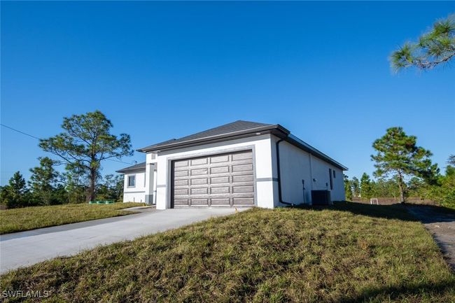 View of property exterior with cooling unit, a garage, and a yard | Image 21