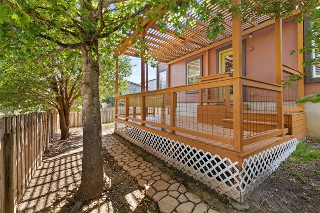 Wooden deck with a fenced backyard and a pergola | Image 34