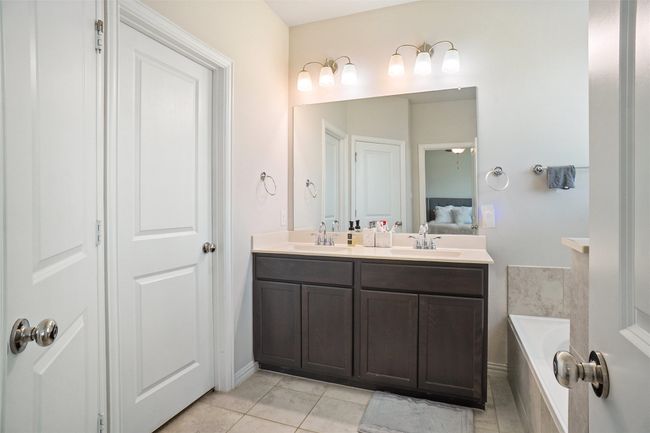 Full bath featuring double vanity, a bath, tile patterned flooring, and ensuite bath | Image 12