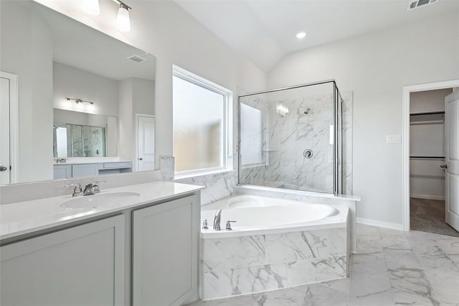 Full bathroom with a garden tub, a marble finish shower, vanity, marble look tile flooring, and a spacious closet | Image 17
