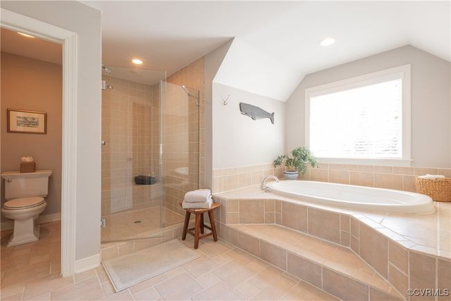 Full bath with a shower stall, a bath, tile patterned flooring, vaulted ceiling, and toilet | Image 35
