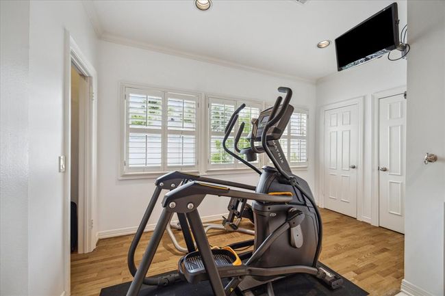 Extra living space in the primary bath that current owners have used for their workout space. But could be a nice relaxation area as well with this abundant natural light. Walk-in closets on either side of this space and behind the doors is extra storage! | Image 22