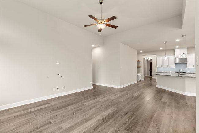 Unfurnished living room with light wood-type flooring, a sink, a ceiling fan, recessed lighting, and a chandelier | Image 15