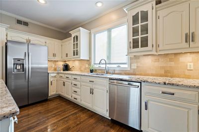 Kitchen featuring white cabinets, sink, dark hardwood floors, and stainless steel appliances | Image 3