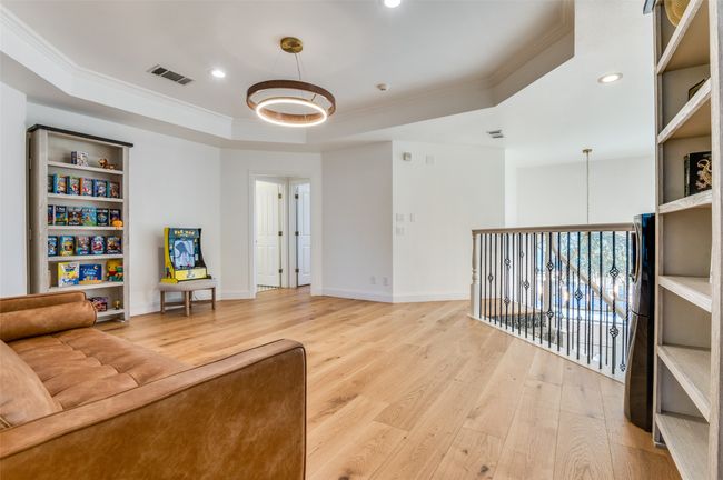 Living area with a tray ceiling, light wood-style flooring, and ornamental molding | Image 29
