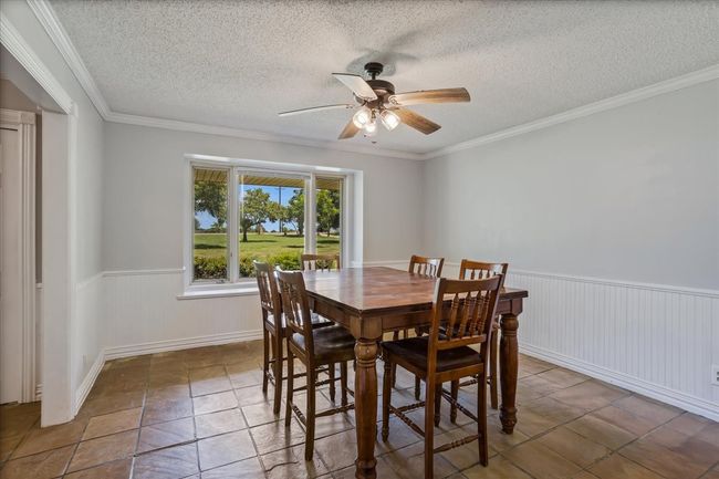 Dining area with ceiling fan, wainscoting, and ornamental molding | Image 12