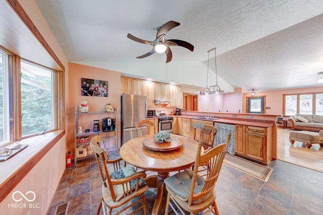 dining area with ceiling fan, healthy amount of natural light, vaulted ceiling, and a textured ceiling | Image 44