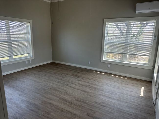 Unfurnished room with wood finished floors, a wall unit AC, and plenty of natural light | Image 20