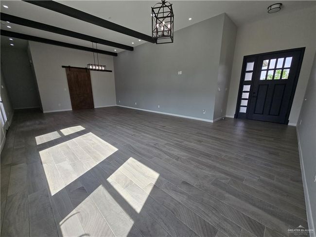 Entryway with a barn door, a chandelier, baseboards, recessed lighting, and a towering ceiling | Image 4