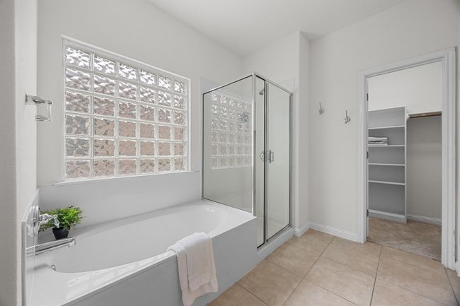Primary En-Suite Bathroom featuring a soaking bath tub, separate shower, and a spacious closet | Image 20