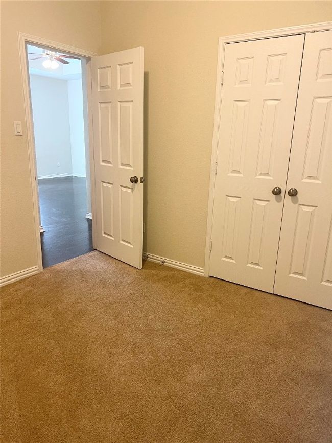 Unfurnished bedroom with carpet floors, baseboards, and a closet | Image 8