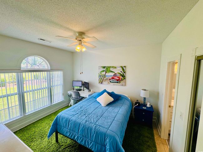 Tiled bedroom featuring a ceiling fan and a textured ceiling | Image 17