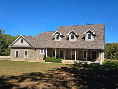 New england style home with a front lawn and a patio | Image 3