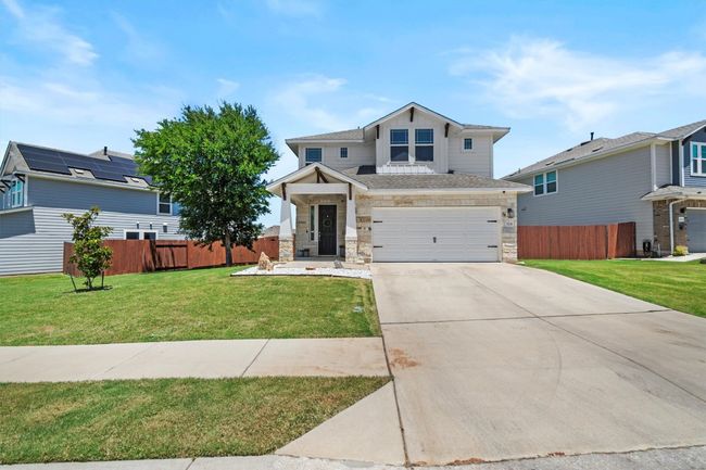 Craftsman-style home with driveway, an attached garage, stone siding, and roof with shingles | Image 7