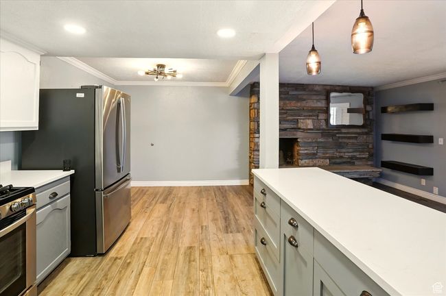 Kitchen featuring appliances with stainless steel finishes, light wood-style floors, gray cabinetry, baseboards, and light countertops | Image 12