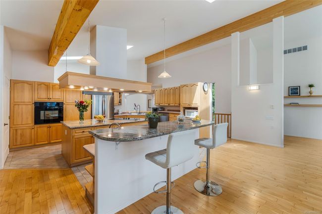 Kitchen with oven, high vaulted ceiling, a kitchen breakfast bar, a center island, and beam ceiling | Image 12
