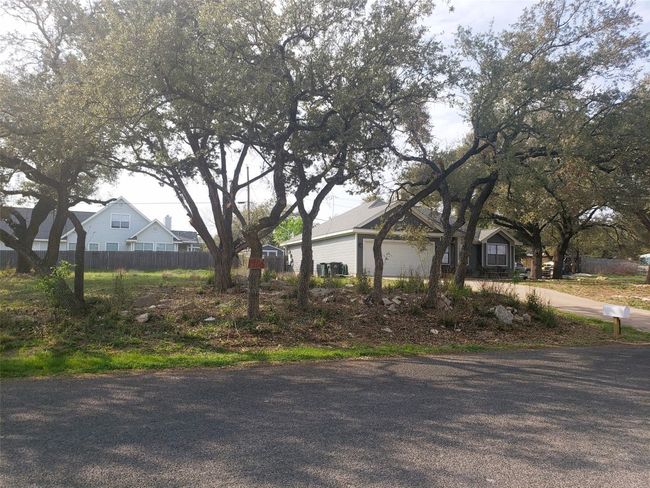 View of property exterior with driveway, a garage, and fence | Image 6
