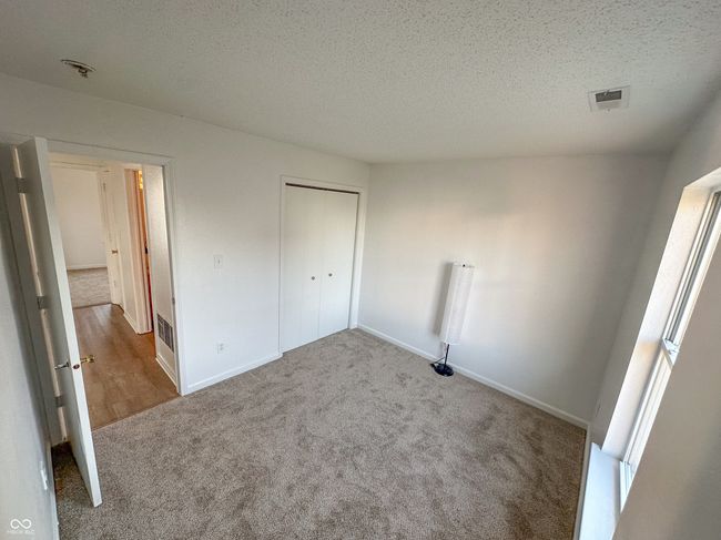 unfurnished bedroom with a textured ceiling, baseboards, and carpet floors | Image 26