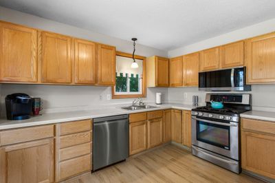 The sun-filled kitchen welcomes you with brand-new hardwood floors that extend throughout the main level. | Image 2