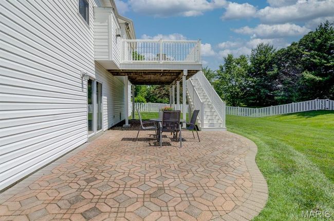 The basement slider opens to a patio with ornate pavers. | Image 36