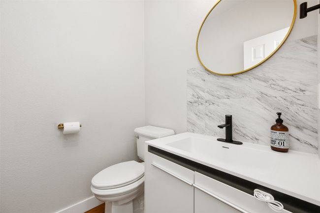 Half bathroom with tasteful backsplash, vanity, baseboards, and toilet | Image 19