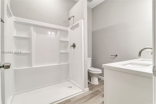 Bathroom with a shower, hardwood / wood-style floors, toilet, and dual vanity | Image 28