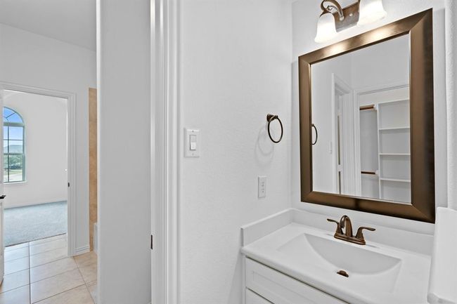 This bedroom also provides access to the shared bathroom and includes a private sink vanity, offering both convenience and personal space. | Image 19