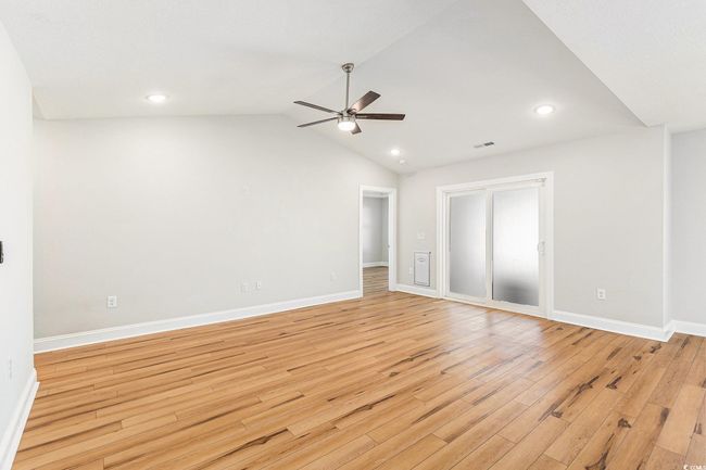 Unfurnished room featuring ceiling fan, light wood finished floors, recessed lighting, and lofted ceiling | Image 6