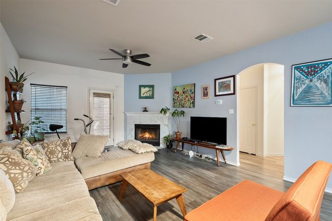 A large archway from the kitchen overlooks the dining and living with a corner fireplace with tile surround. | Image 16